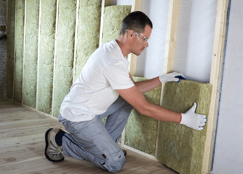 Man plaatst isolatiemateriaal in een wand